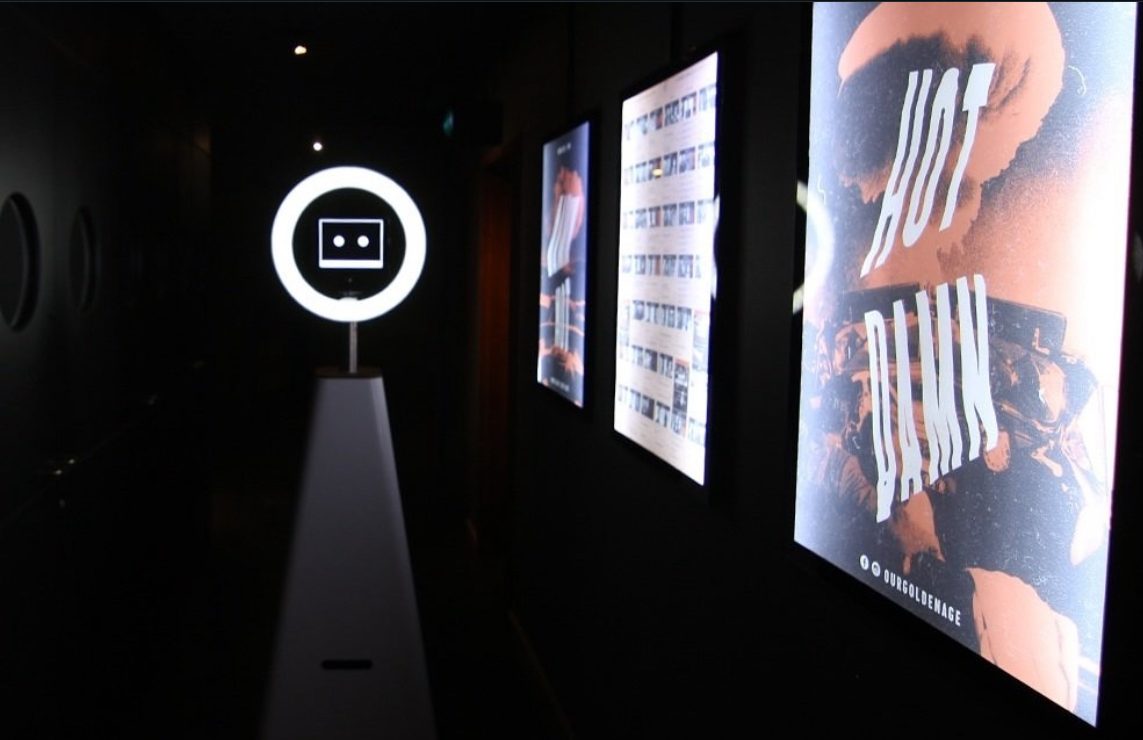 Printed photo strips from a private party displayed beside the glowing ring light